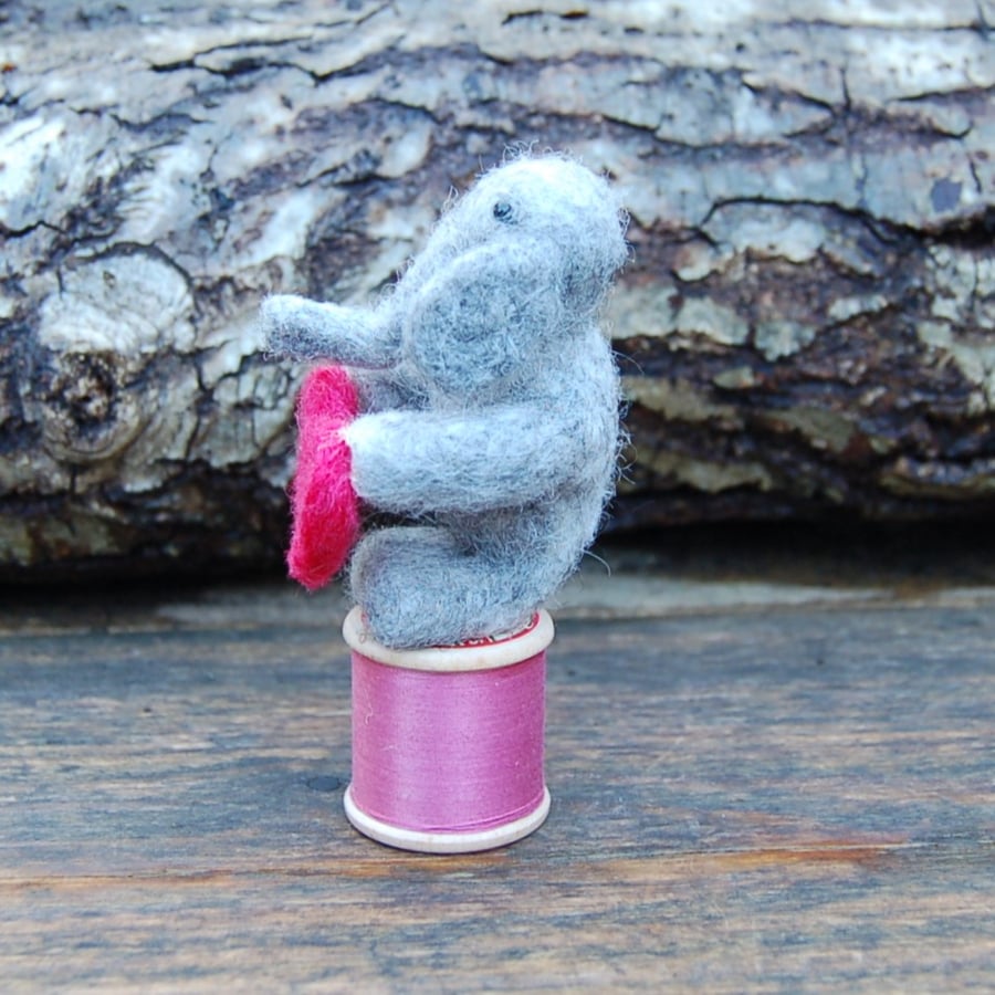 Miniature elephant on a vintage cotton reel, needlefelt elephant holding   heart
