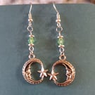 Silver crescent moon dangle earrings with green bead detail