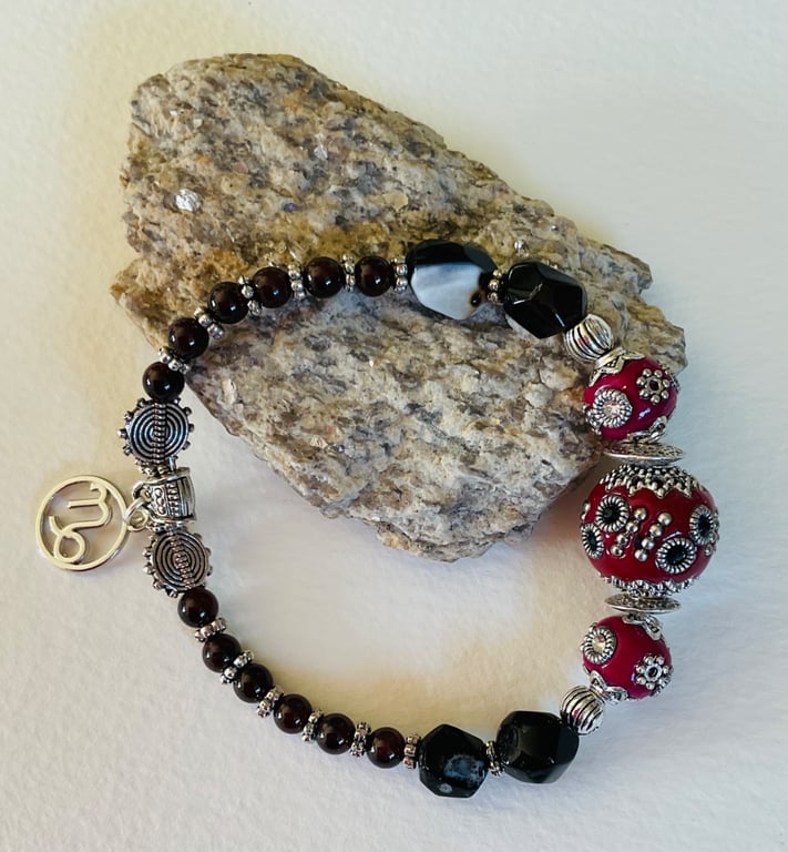 Capricorn January birthday charm bracelet featuring garnet and onyx