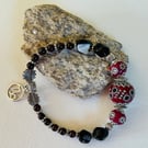 Capricorn January birthday charm bracelet featuring garnet and onyx
