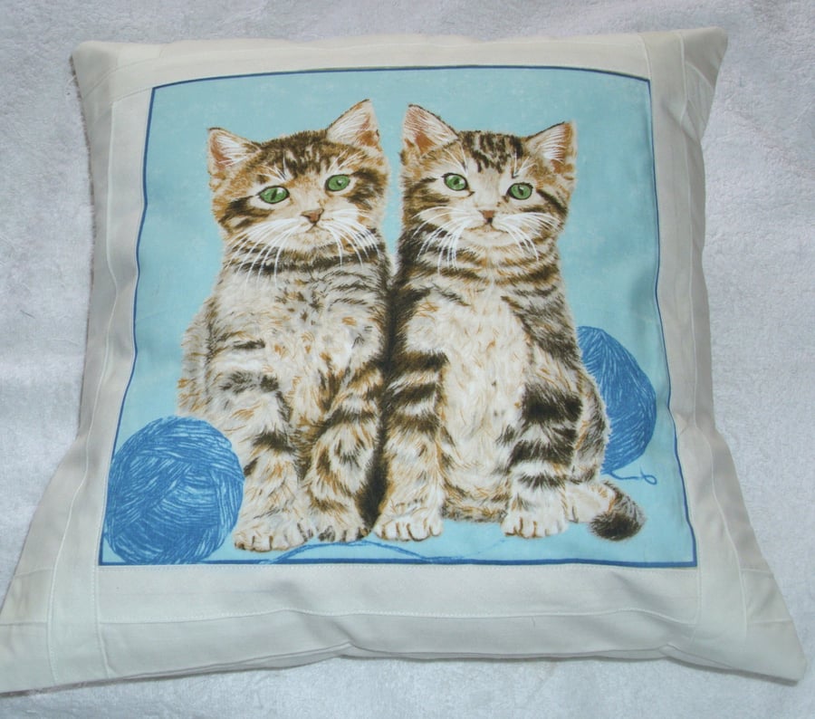Pretty tabby kittens with balls of wool cushion