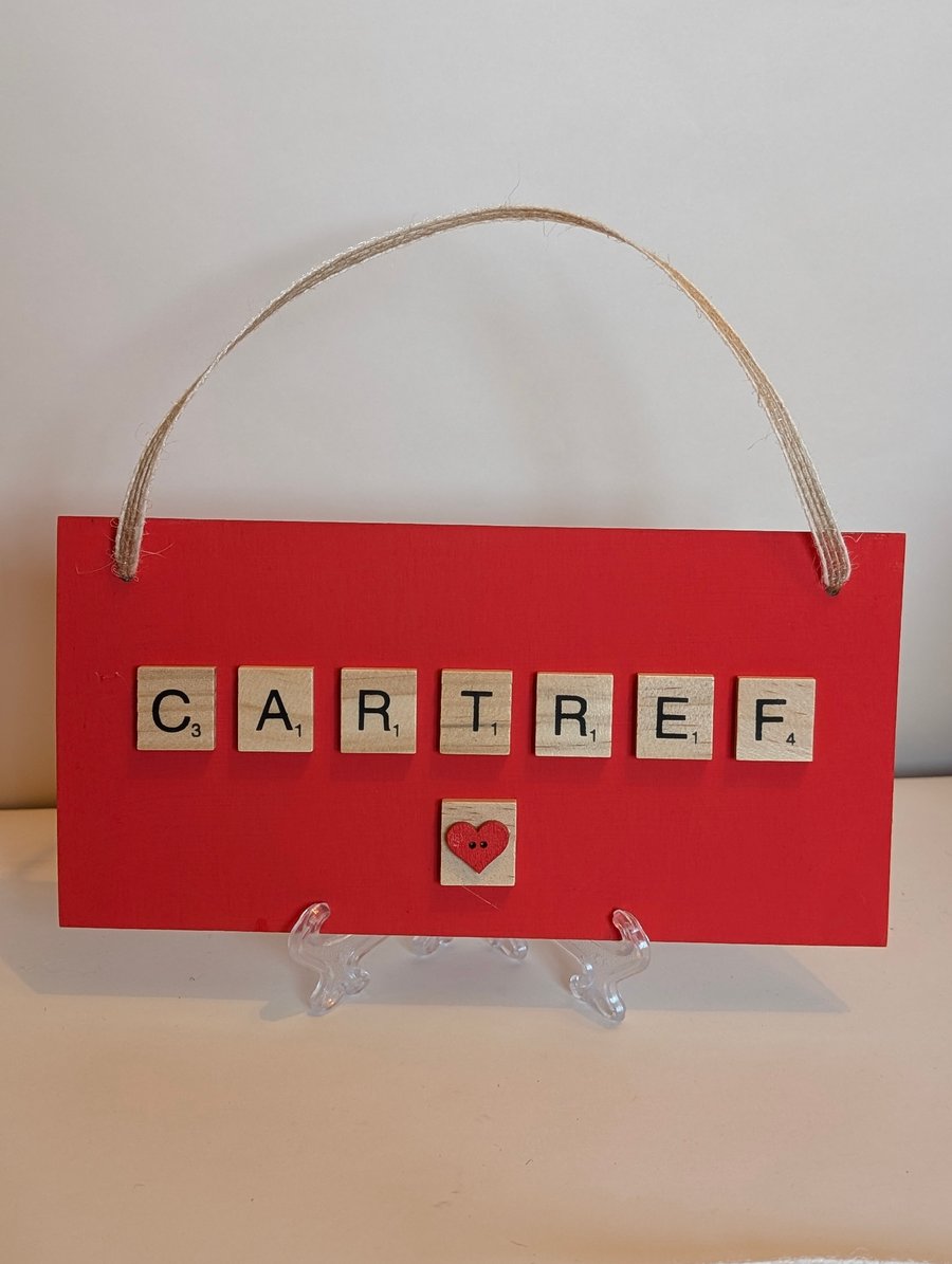 Wooden sign with scrabble tiles spelling Cartref - Home