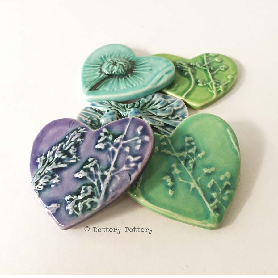 Set of five ceramic heart tiles with flower imprints and bright glazes purples