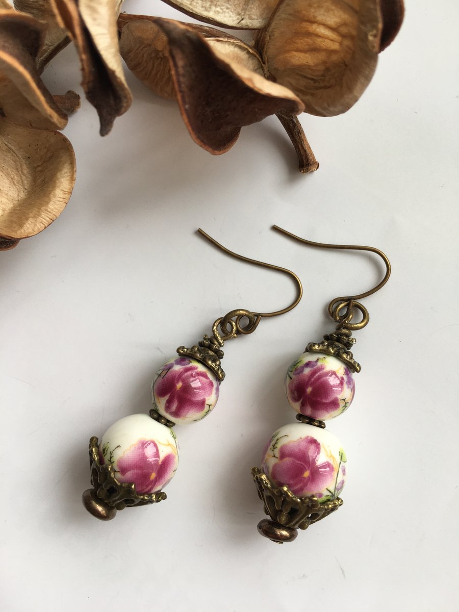 Purple flowers painted ceramic bead dangle earrings.