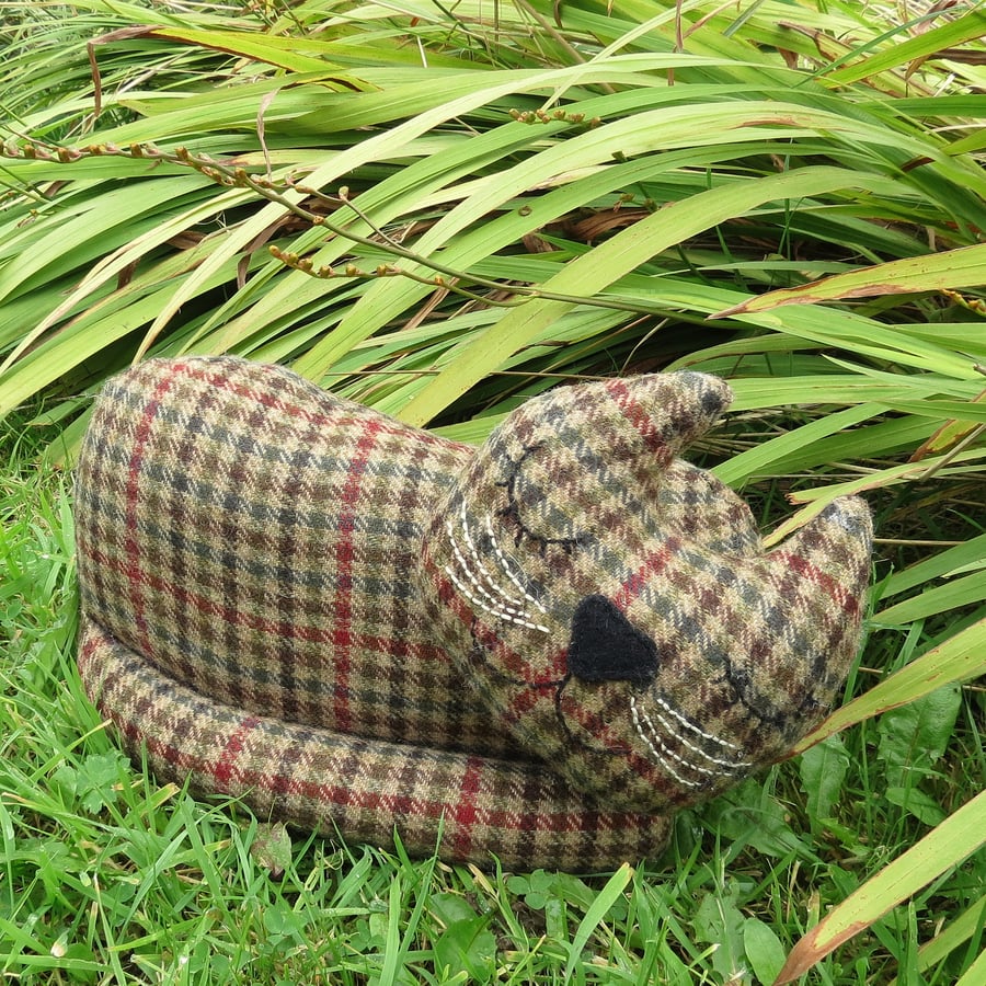 A snoozy cat doorstop made from tactile pure wool.