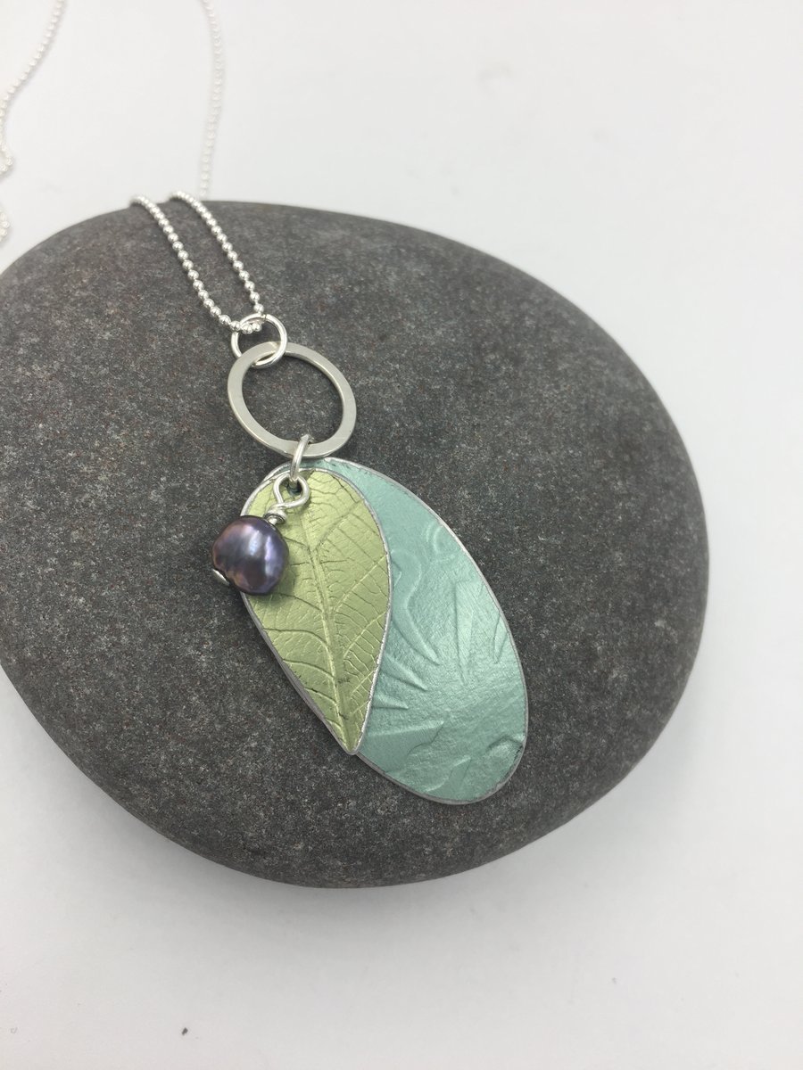 Layered pendant in teal and pale green with pearl and silver ring.