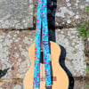 1 inch wide bright blue ukulele shoulder strap with flowers and skeletons
