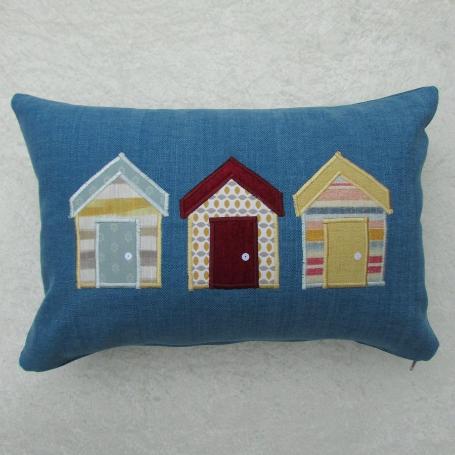 Rectangular beach huts cushion in blue with yellow, red and blue huts