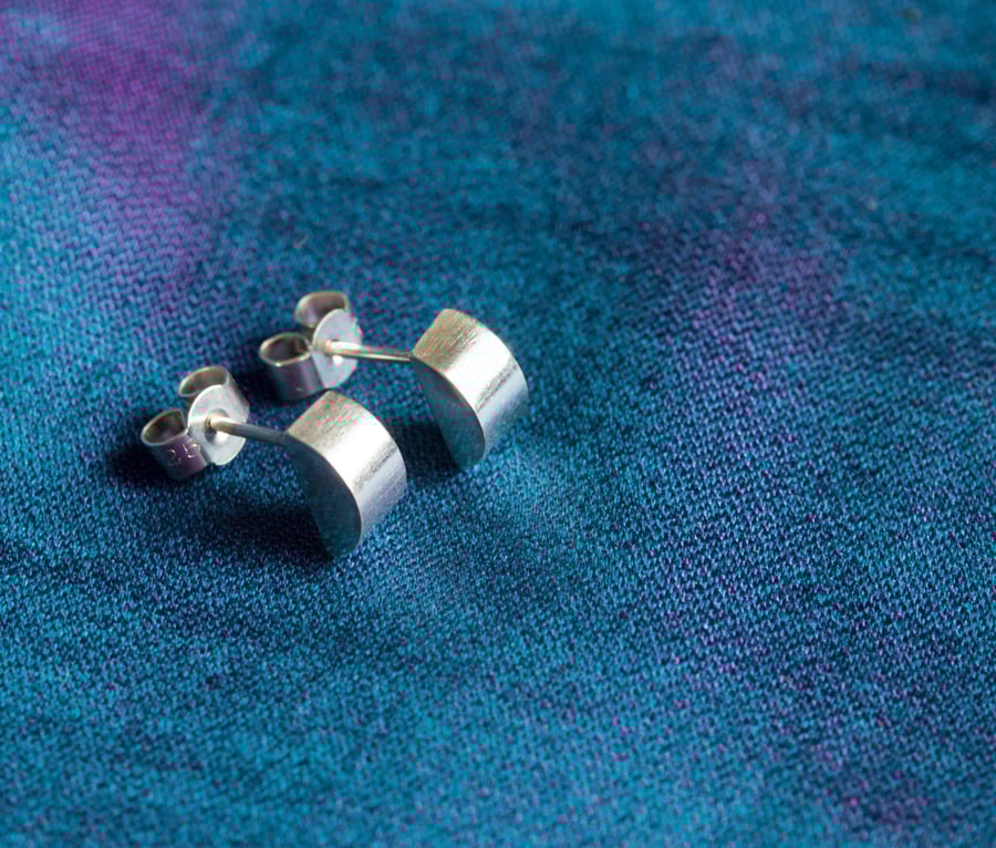 A pair of silver half-moon stud earrings. Contemporary, elegant, sleek!