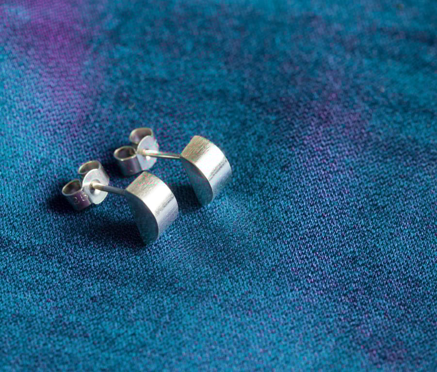 A pair of silver half-moon stud earrings. Contemporary, elegant, sleek!