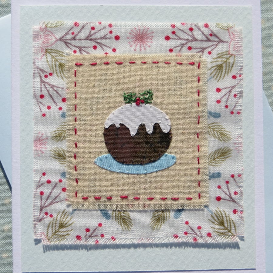 Hand-stitched pudding with embroidered details and pretty fabric background