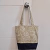 Tote bag in denim and green with long handles and boxed base.