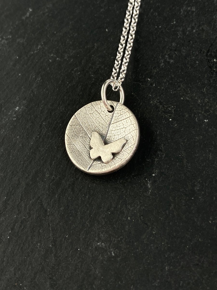 Silver concave leaf imprint pendant necklace with butterfly detail