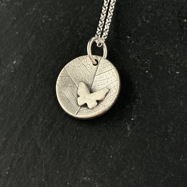 Silver concave leaf imprint pendant necklace with butterfly detail