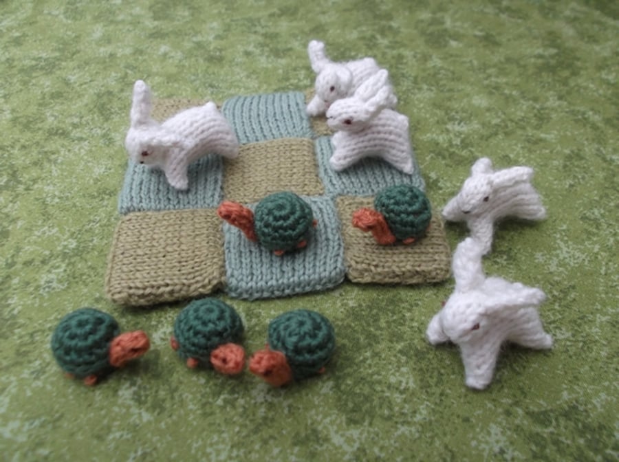 Knitted hare and tortoise noughts and crosses game set