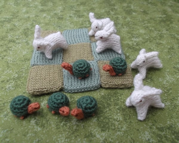 Knitted hare and tortoise noughts and crosses game set