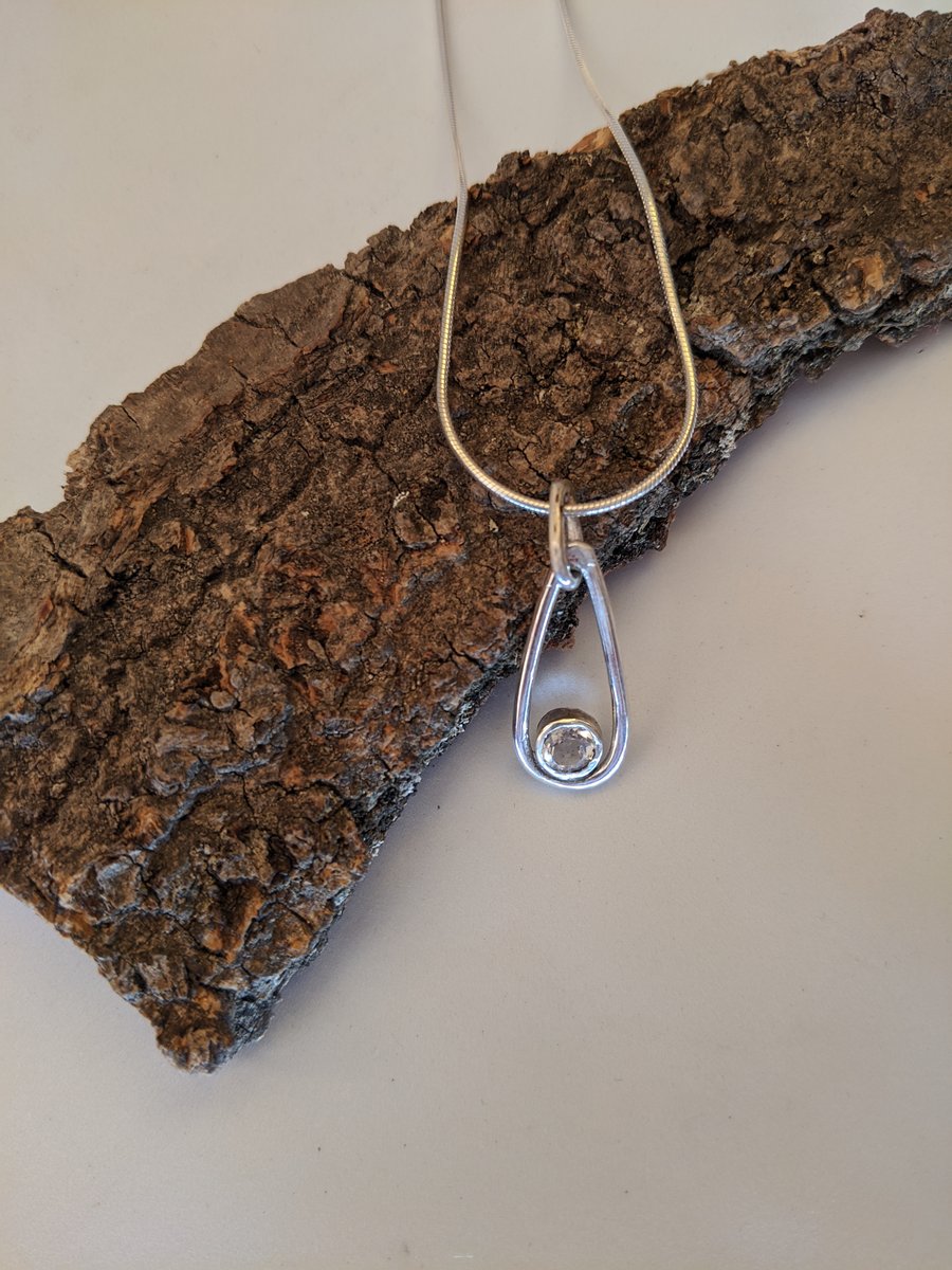 Sky topaz set in sterling silver pendant on a snake chain
