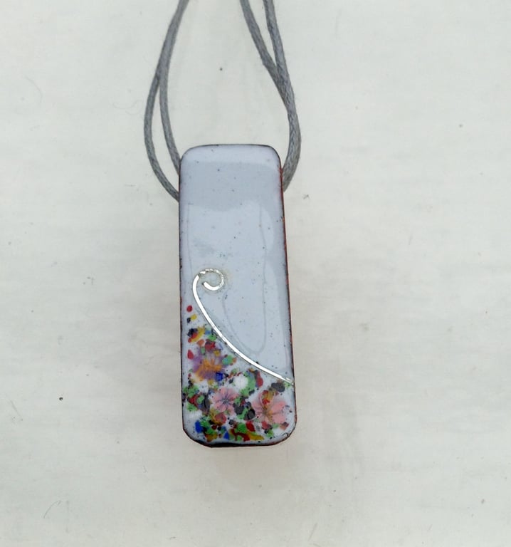 SMALL, SLIM, OBLONG FLORAL ENAMELLED PENDANT WITH STERLING SILVER DESIGN