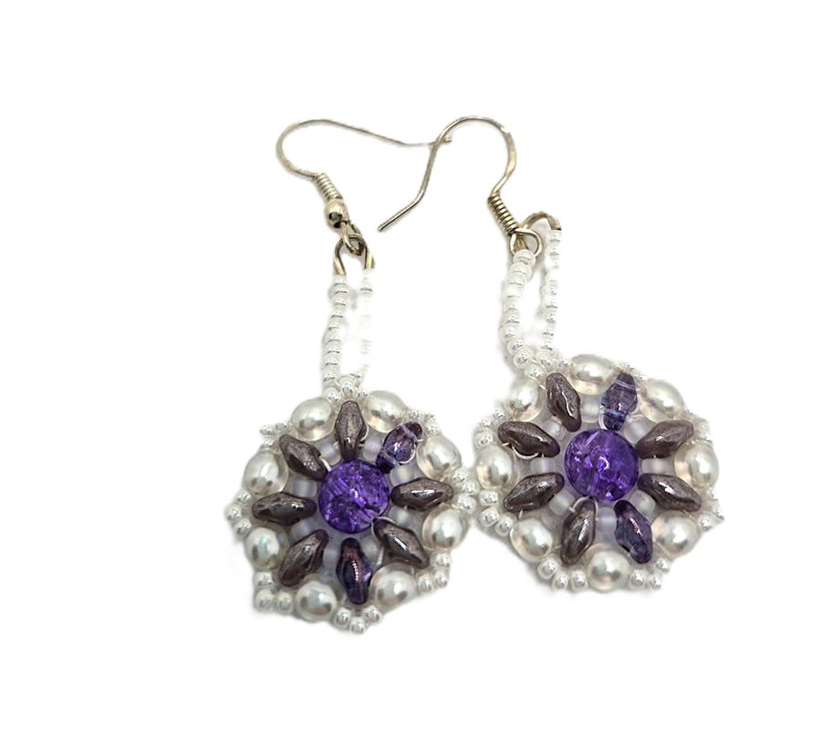 Handmade white beaded earrings with larger purple bead in the centre
