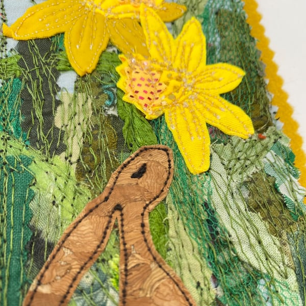 Upcycled embroidered spring rabbit and daffodil home decoration. 
