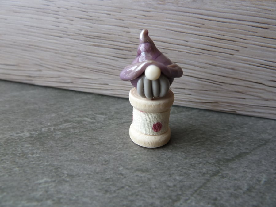 glass gnome on wooden spool