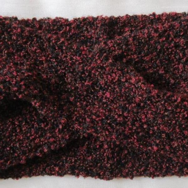 A hand-knitted turban-style headband in boucle yarn with a cross-over front