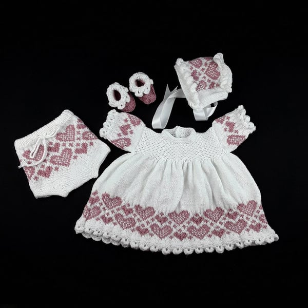 knitted baby dress set, white with rose pink hearts, matching bonnet and booties