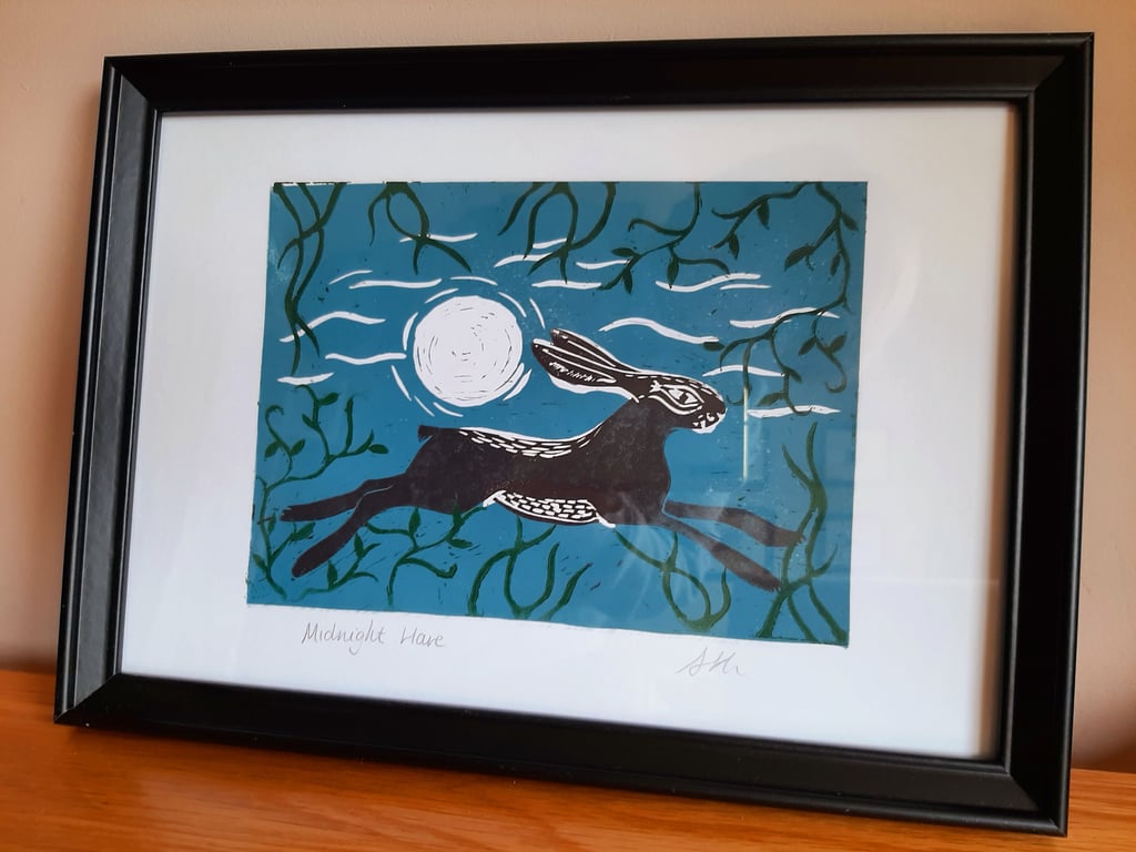 Original linoprint of a hare running through woodland under a moonlit sky