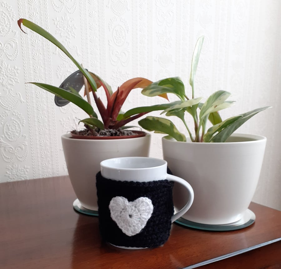 BLACK CROCHET MUG COZY WITH A GLITTERY HEART  ON  EITHER SIDE