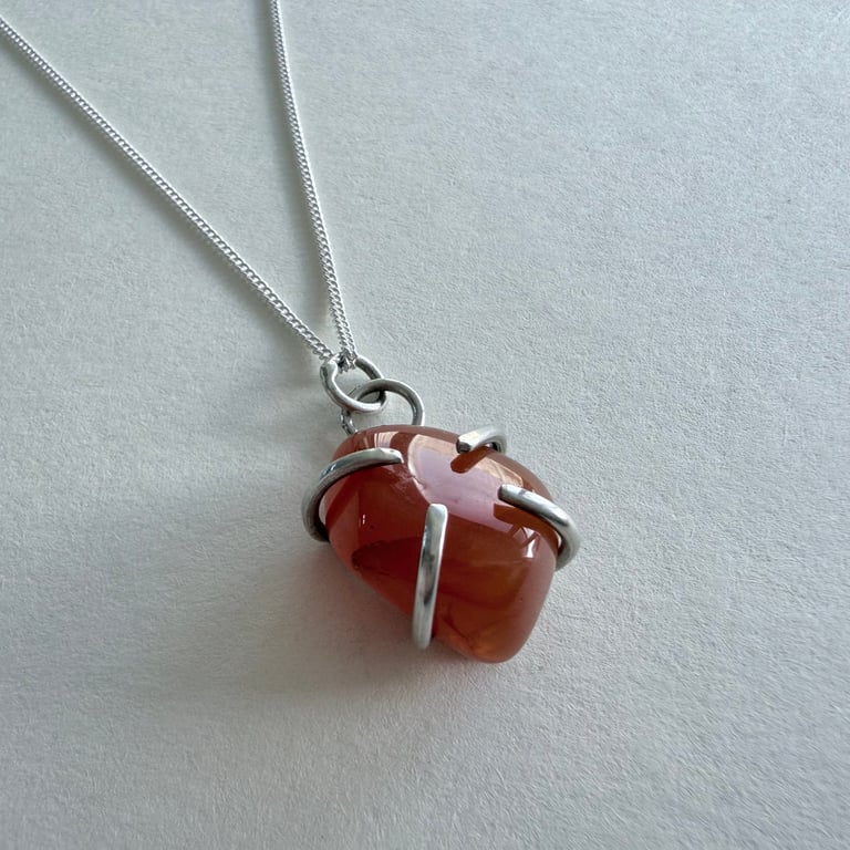 Polished Carnelian stone pendant in handmade silver claw setting