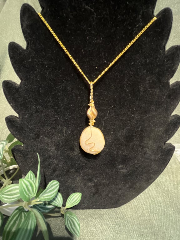 Beautiful wire wrapped pebble pendant on gold coloured chain. 