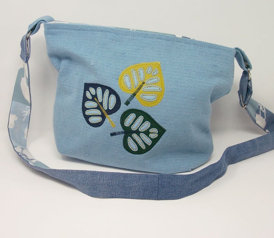 Fabric shoulder bag in soft blue with leaf applique details