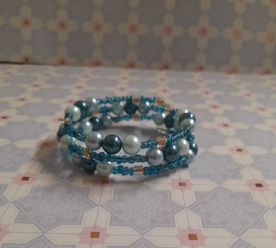 SHADES OF TEAL, TURQUOISE AND GOLD MEMORY WIRE BRACELET.