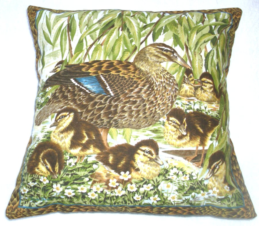 Mallard duck with her eight fluffy golden ducklings by the river bank cushion
