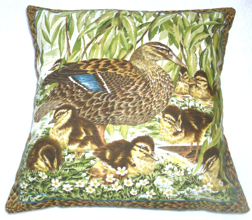 Mallard duck with her eight fluffy golden ducklings by the river bank cushion