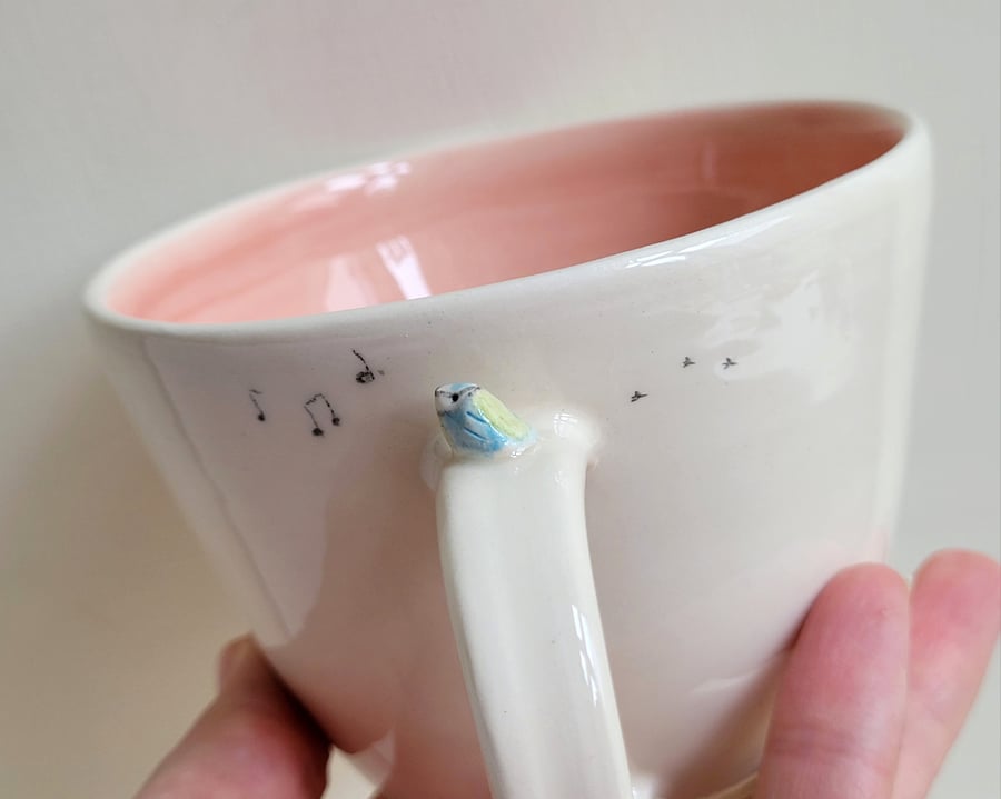 Handmade blue tit mug with pink glaze and musical notes 