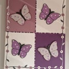 A quartet of sequinned butterflies on canvas. 