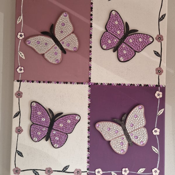 A quartet of sequinned butterflies on canvas. 