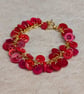 Red button bracelet with gold chain and toggle clasp  - Image 1