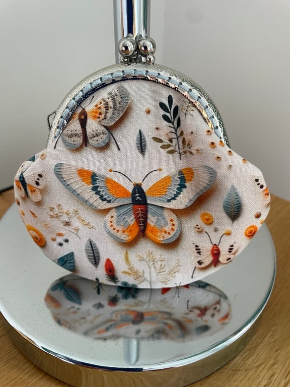 Clasp Purse in a 3D Butterfly Themed Fabric.