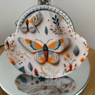 Clasp Purse in a 3D Butterfly Themed Fabric.