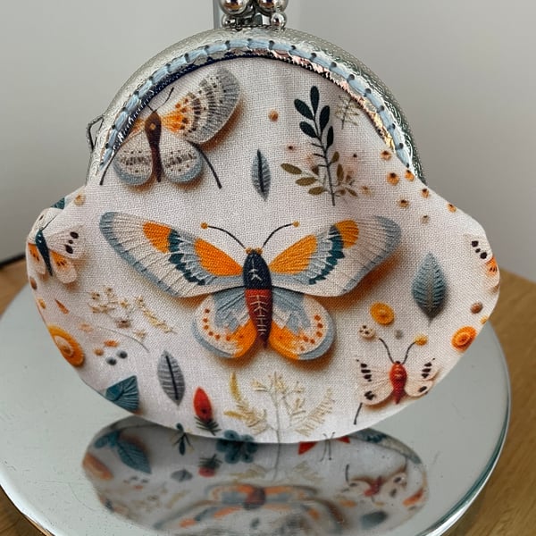 Clasp Purse in a 3D Butterfly Themed Fabric.