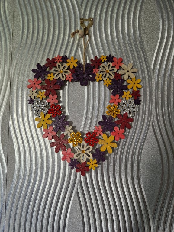 Flower wreath decorated with warm colours and embellished with sequins.