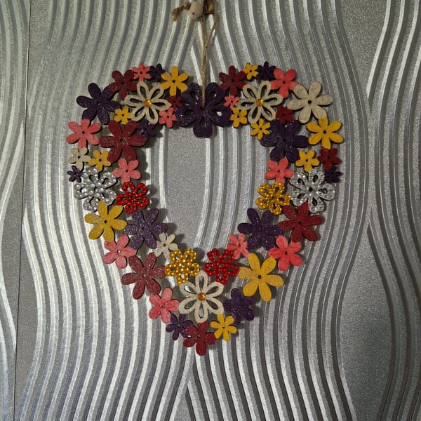 Flower wreath decorated with warm colours and embellished with sequins.