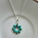 Polymer green and gold flower necklace on a silver plated chain