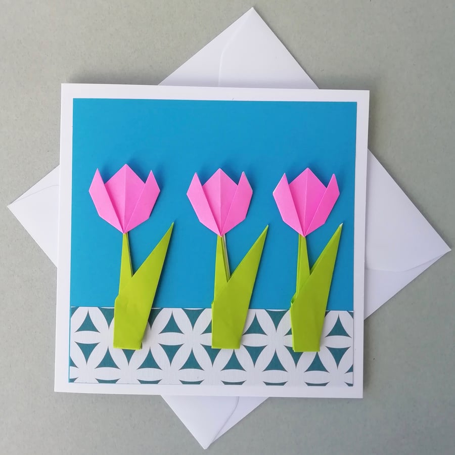 Pink tulips on blue greetings card