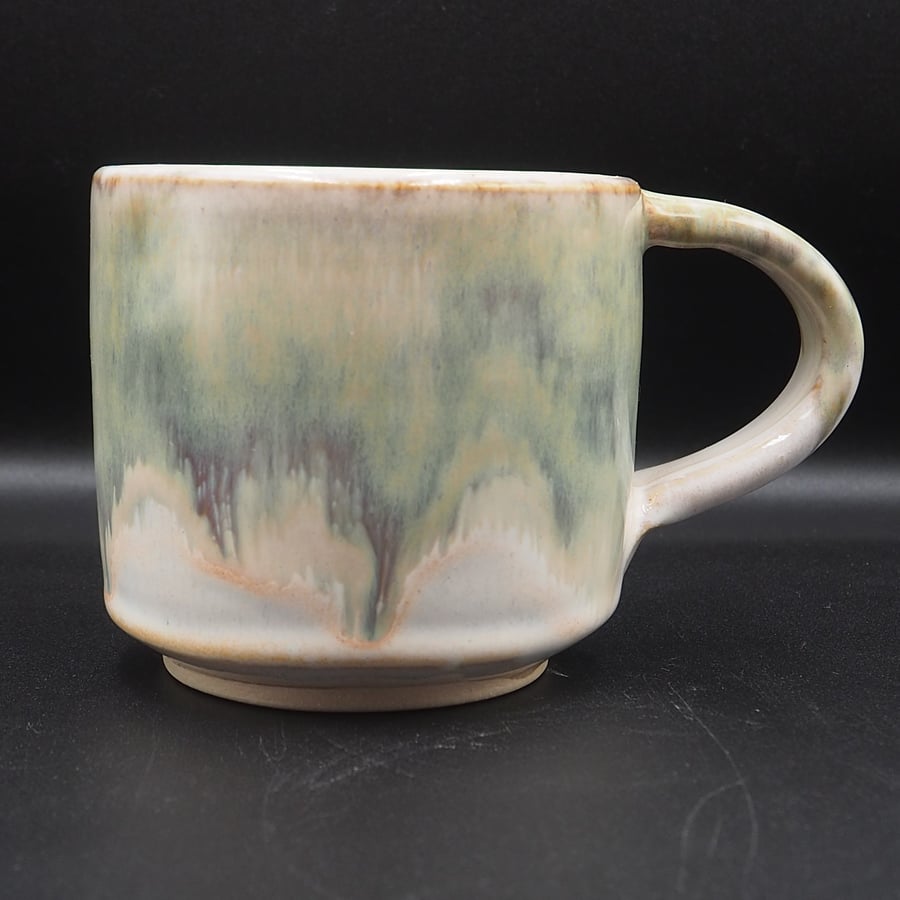 Large stoneware pottery mug finished in green, cream, white glaze.