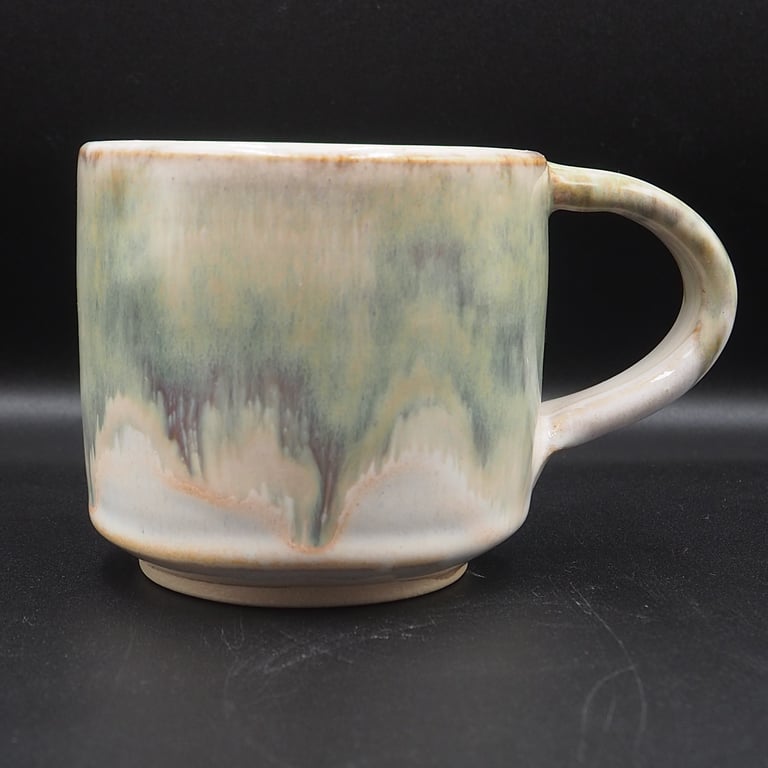 Large stoneware pottery mug finished in green, cream, white glaze.