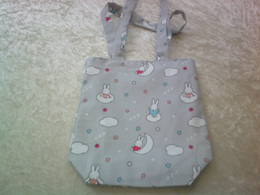 Miffy Rabbit sitting on clouds on a Pale Grey Background