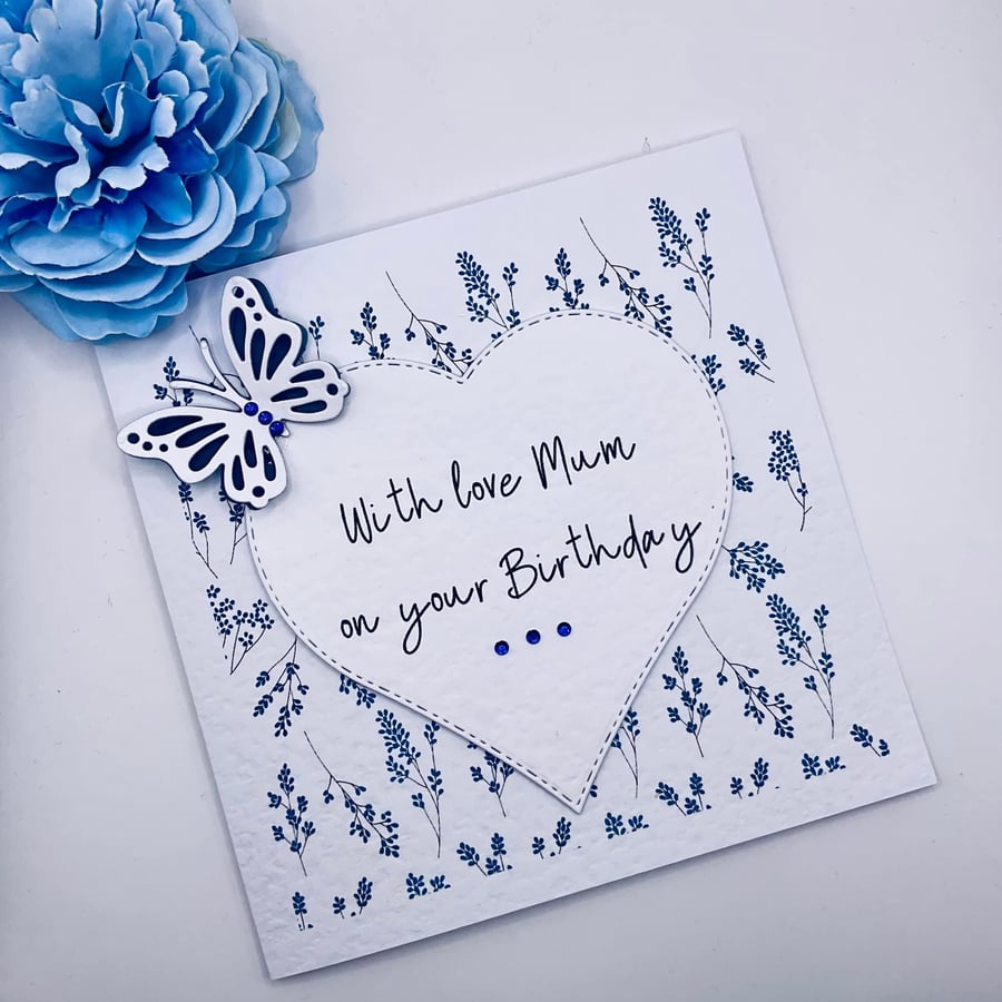 Happy birthday card with blue wildflower, heart with message and  butterfly
